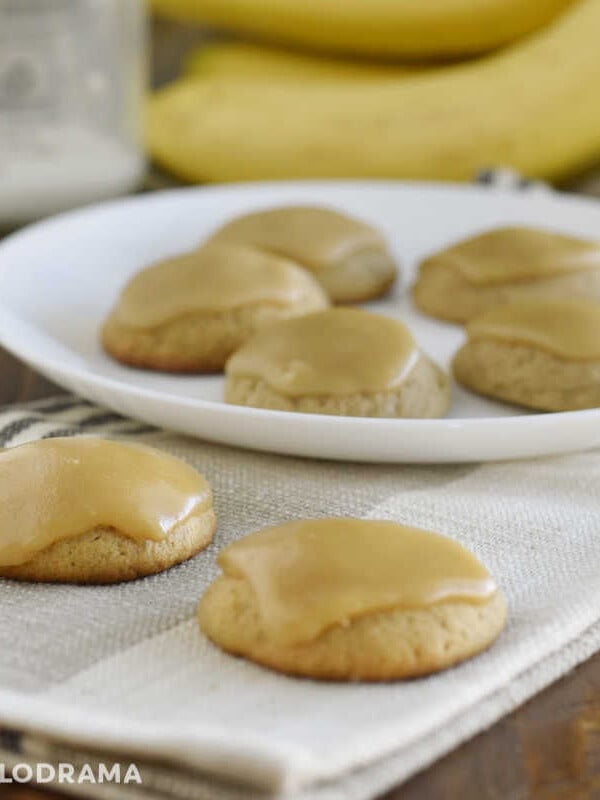 banana bread cookies with brown sugar frosting on a table with milk