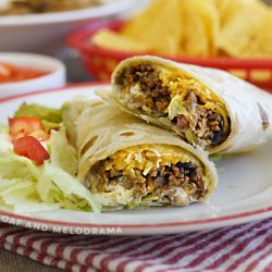 ground beef and black bean burritos with cheese, lettuce and tomatoes on plate