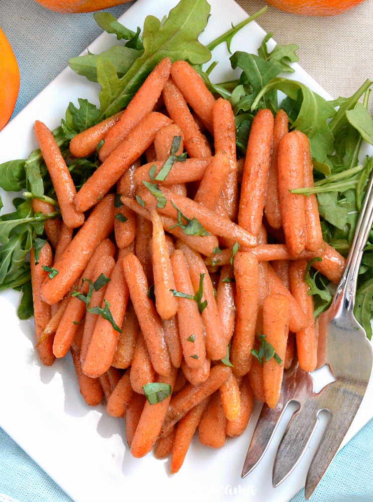 orange ginger glazed carrots on platter with arugula