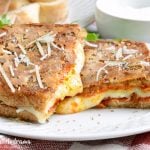 Parmesan crusted pepperoni pizza grilled cheese sandwich on plate