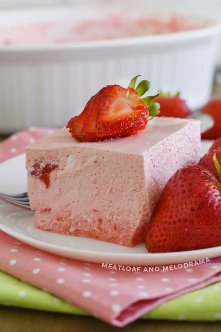 slice of strawberry jello salad with strawberries on a plate