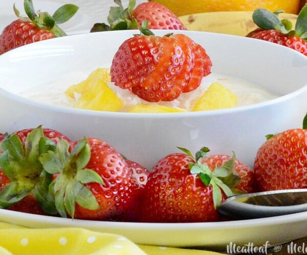 creamy fruit dip in bowl with strawberry on top
