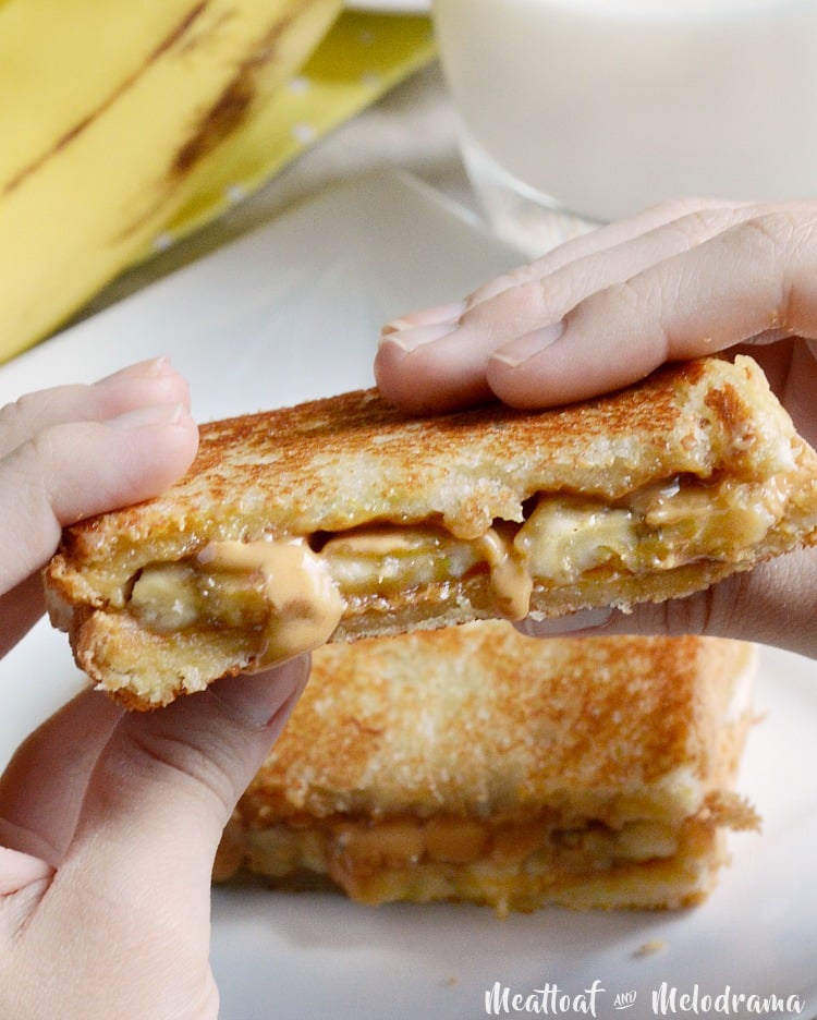 person holding a grilled peanut butter banana sandwich