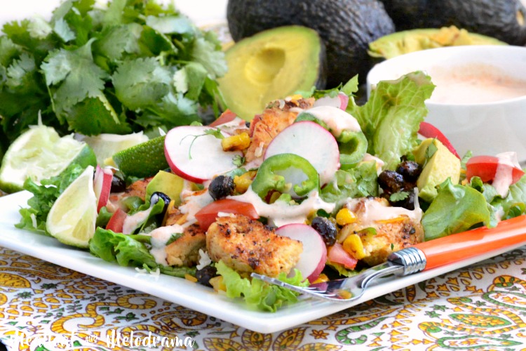 loaded southwest chicken salad with roasted corn and black beans over fresh greens