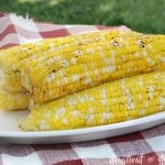 foil grilled corn on the cob on platter in backyard