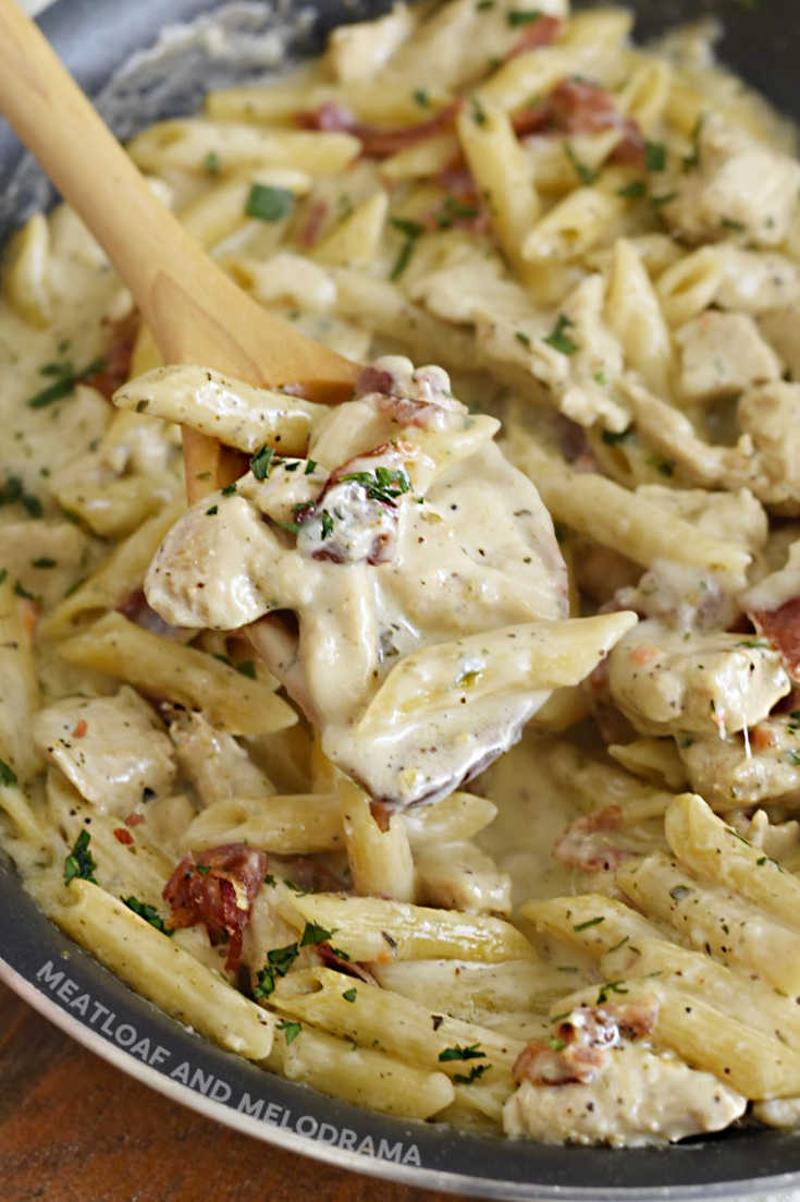 ranch chicken pasta with bacon on a wooden spoon