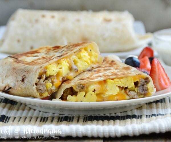 crispy sausage egg breakfast burritos on plate with fruit