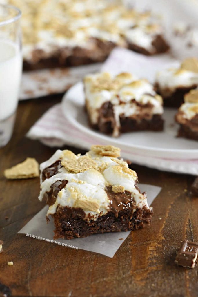 brownie topped with toasted marshmallows, chocolate and graham crackers on wood table