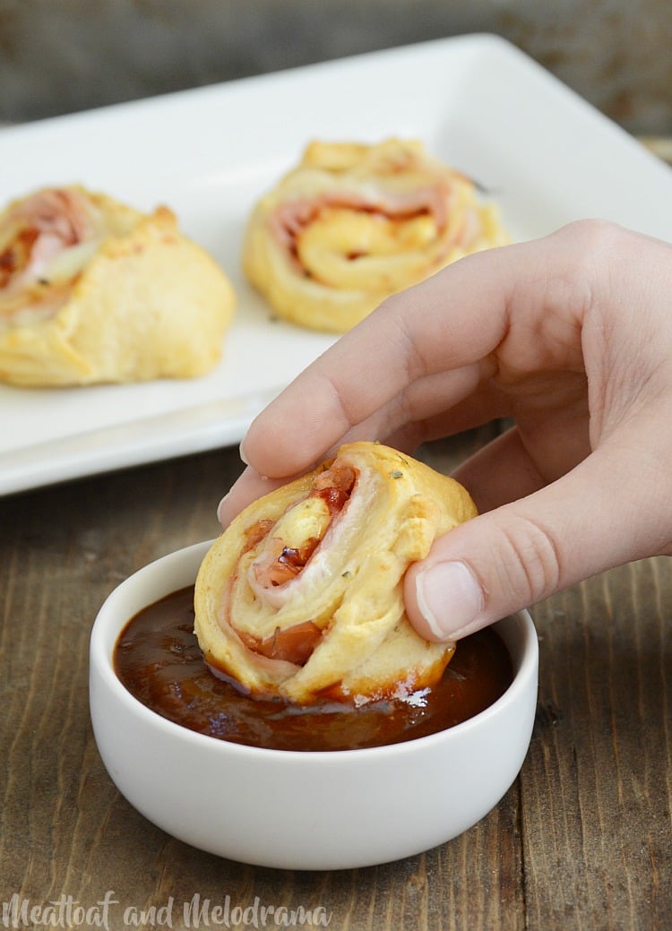 dipping roll ups into barbecue sauce