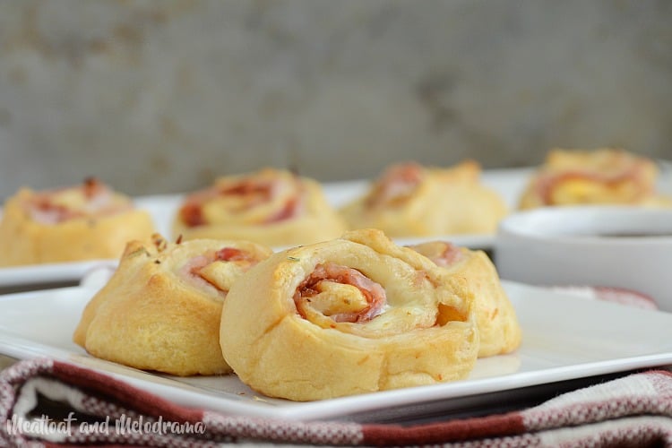 baked ham and cheese roll ups with barbecue sauce on plate