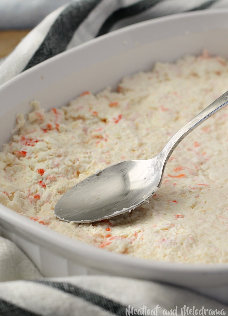 cheesy hot crab dip spread in pan with spoon