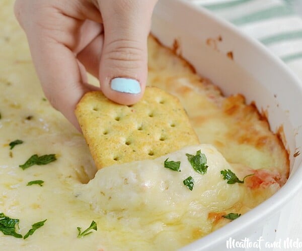cheesy hot crab dip with melted cheese on cracker