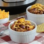 mom's best instant pot chili recipe in bowls with cheese topping
