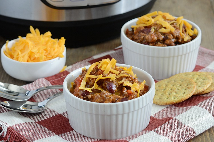 mom's best instant pot chili recipe in bowls with cheese topping