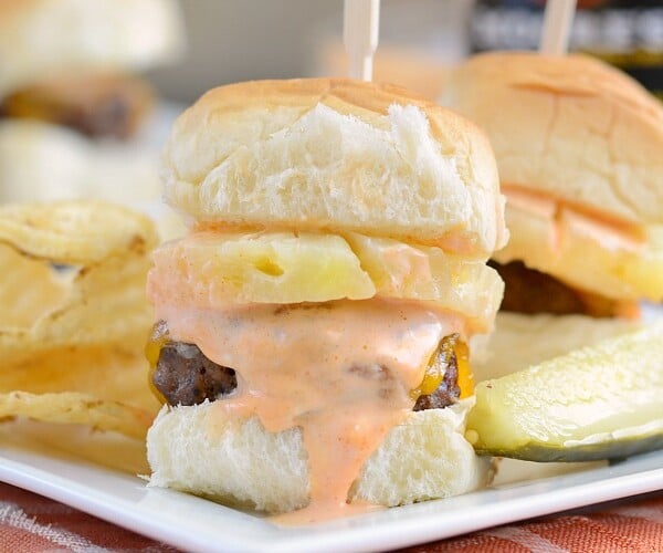 spicy habanero beef sliders with pineapple and cheddar cheese on white plate with pickle and chips