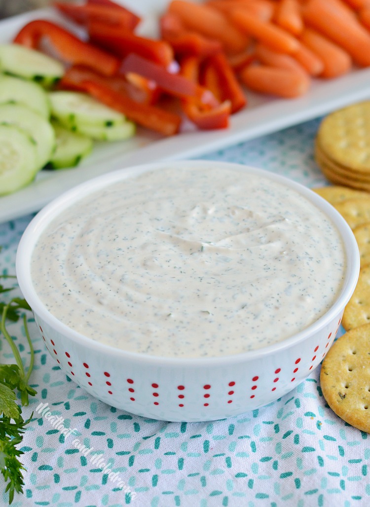 creamy dill dip in red and white bowl with veggies