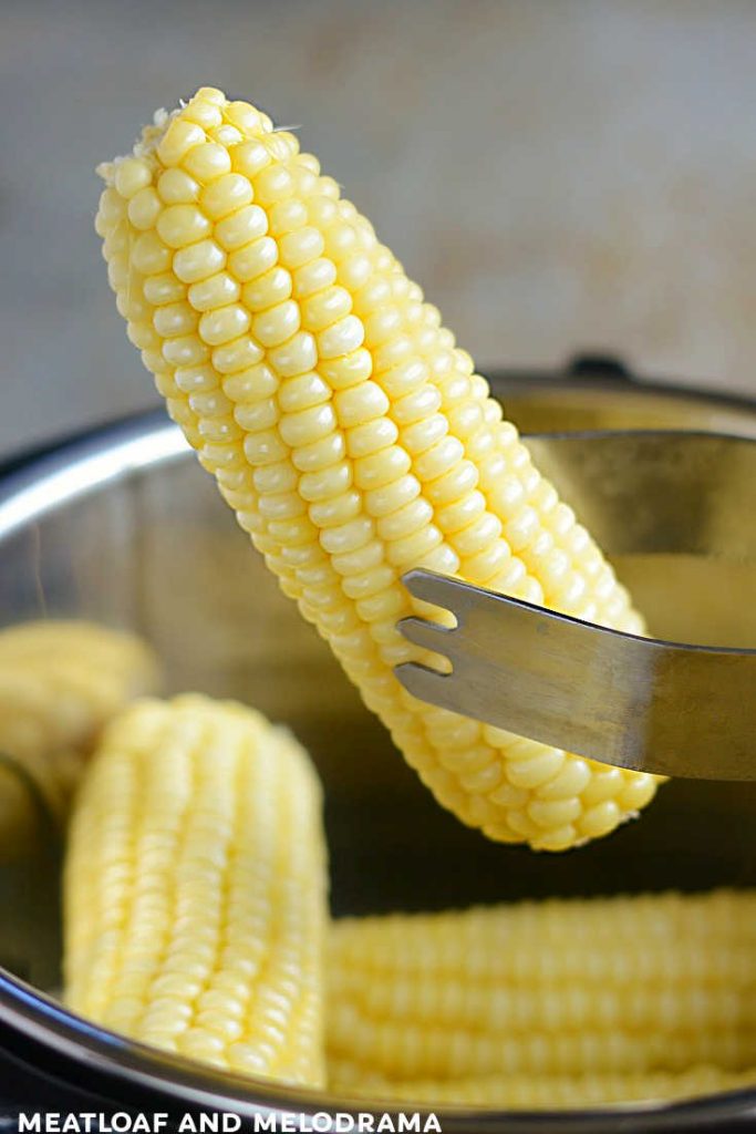ear of cooked corn in tongs over instant pot