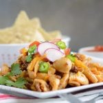 instant pot creamy taco pasta on plate with radishes, peppers and tomatoes