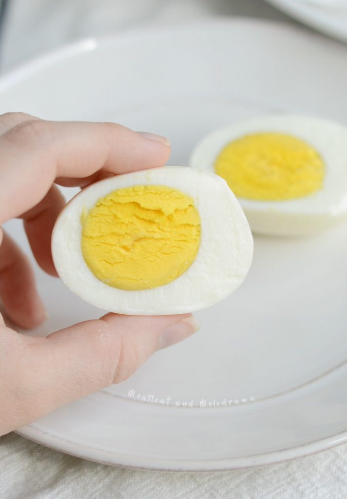  hard boiled eggs sliced open in hand