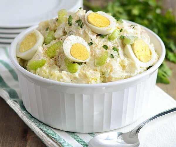 instant pot potato salad with red potatoes in a bowl with hard cooked eggs and celery