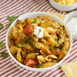 bowl of creamy instant pot taco pasta with sour cream and tomatoes