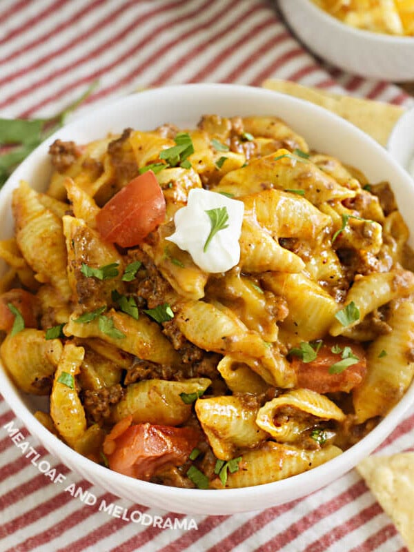 bowl of creamy instant pot taco pasta with sour cream and tomatoes