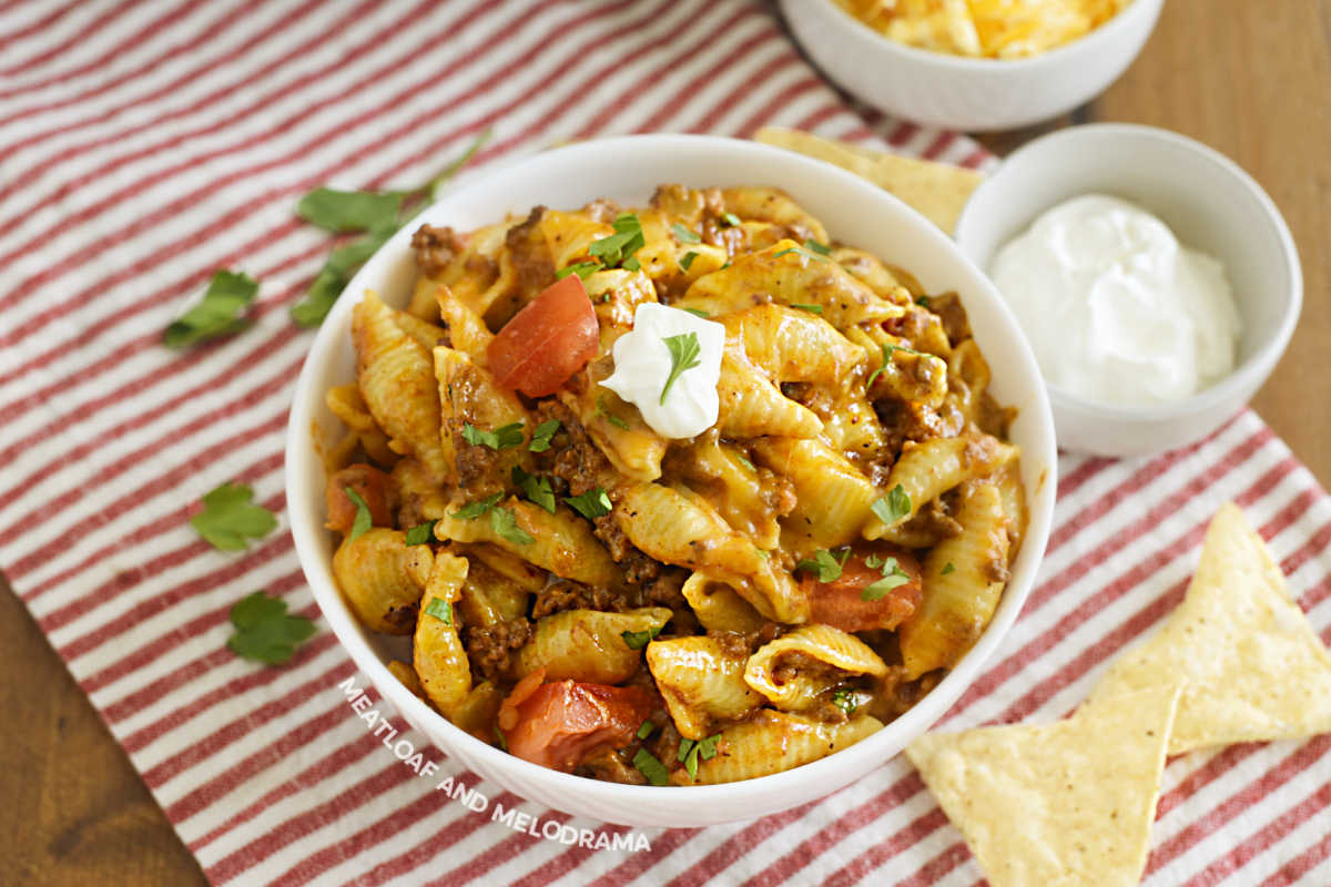 bowl of creamy instant pot taco pasta with sour cream and tomatoes