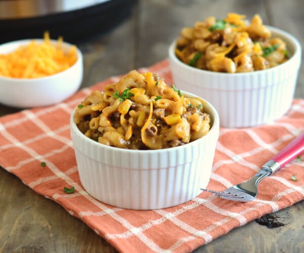 instant pot bbq macaroni and beef with cheddar cheese in white bowls