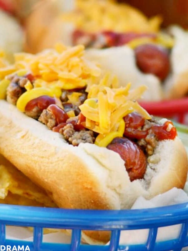 cheeseburger hot dog in blue basket with chips