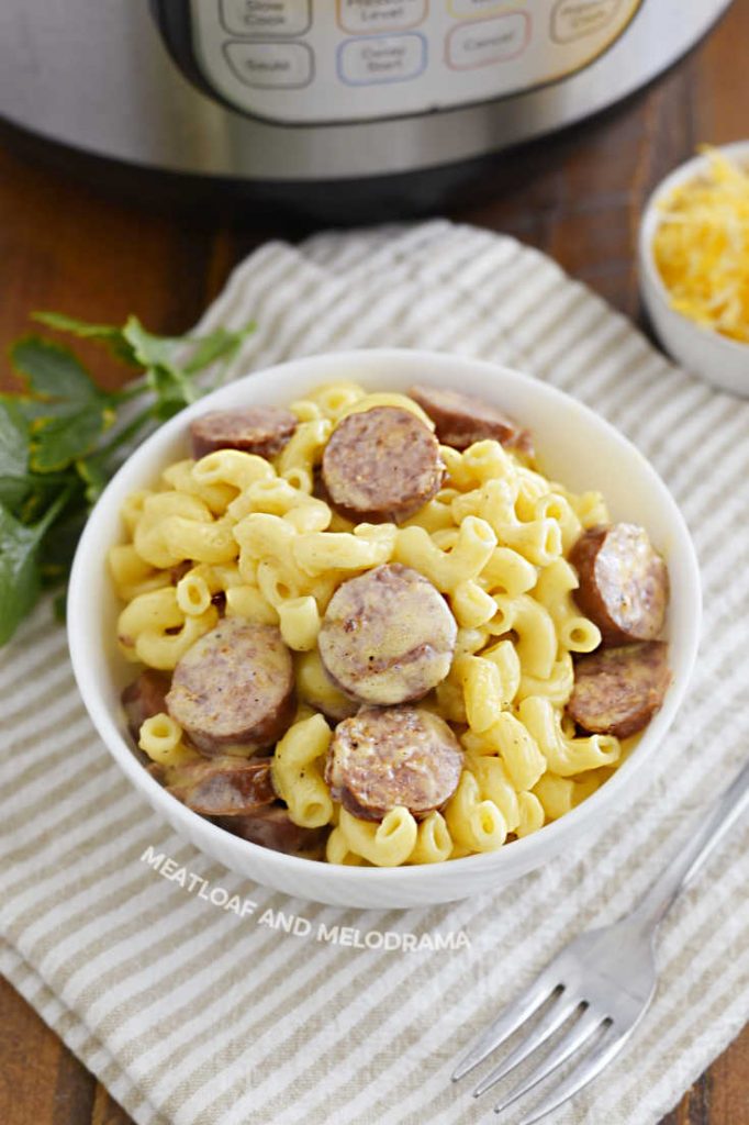 bowl of mac and cheese with sliced smoked sausage