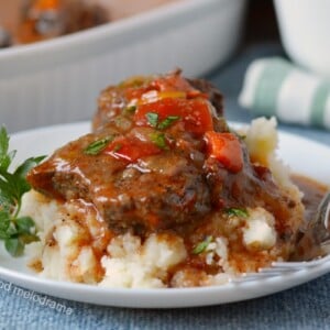 instant pot swiss steak over mashed potatoes on white plate