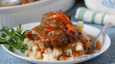 instant pot swiss steak over mashed potatoes on white plate