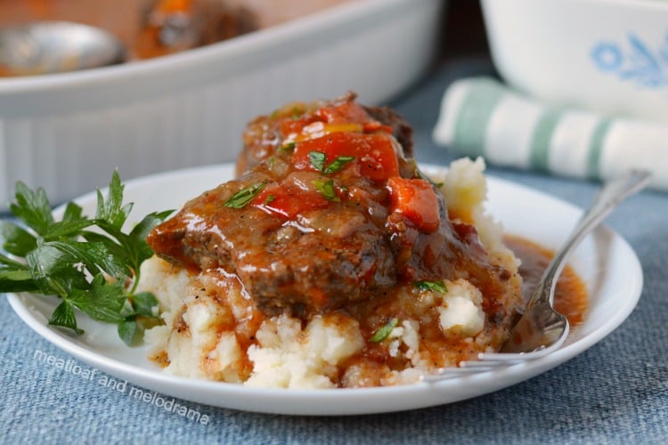 instant pot swiss steak over mashed potatoes on white plate