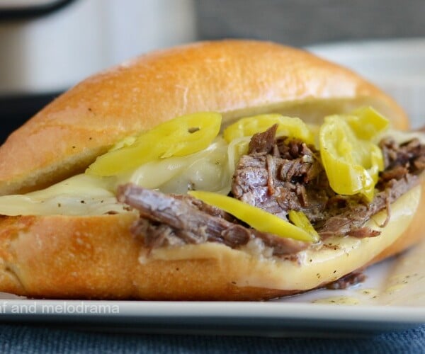 instant pot italian beef sandwiches on roll with provolone cheese and pepperoncini