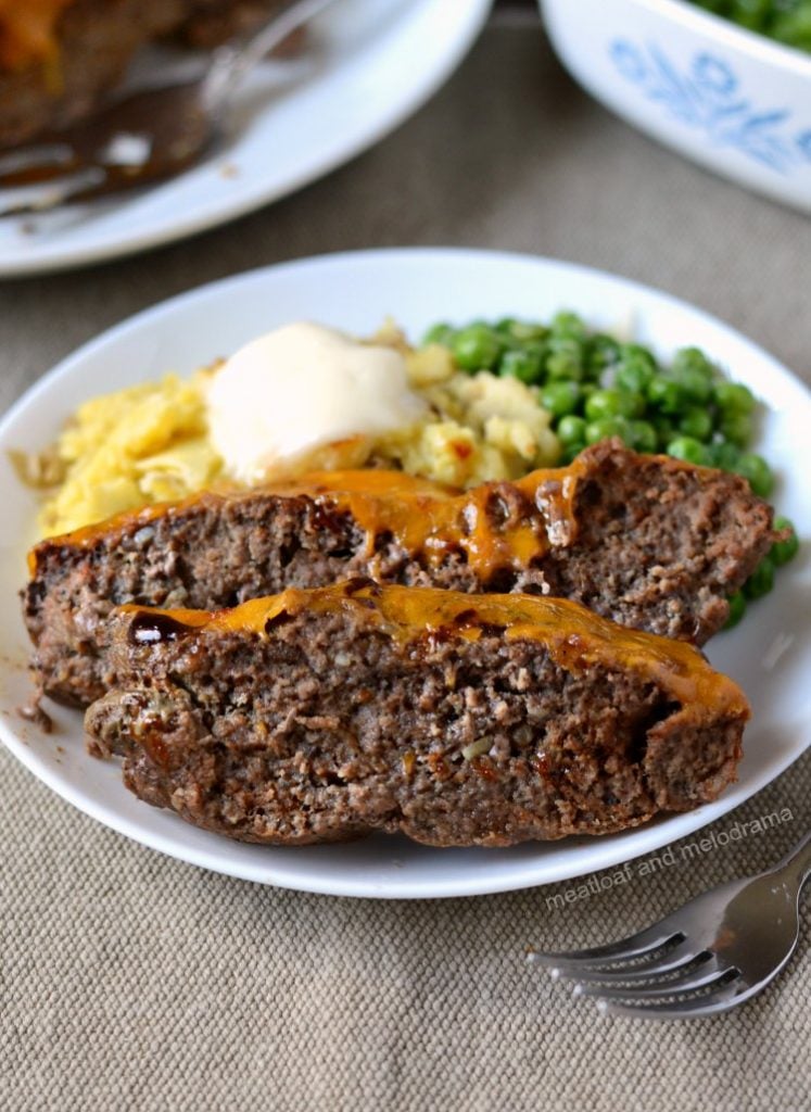 instant pot meatloaf with cheddar bbq sauce on plate with mashed potatoes and peas