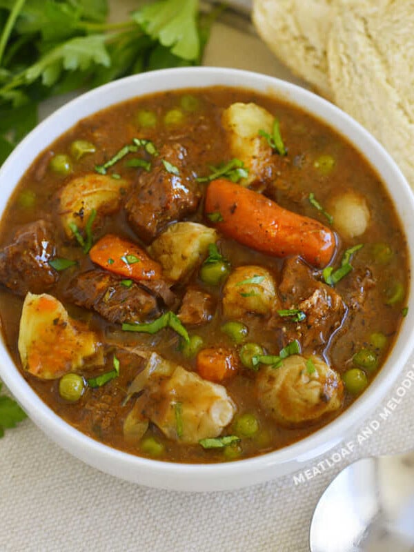 instant pot beef stew with red wine potatoes and carrots and peas in white bowl