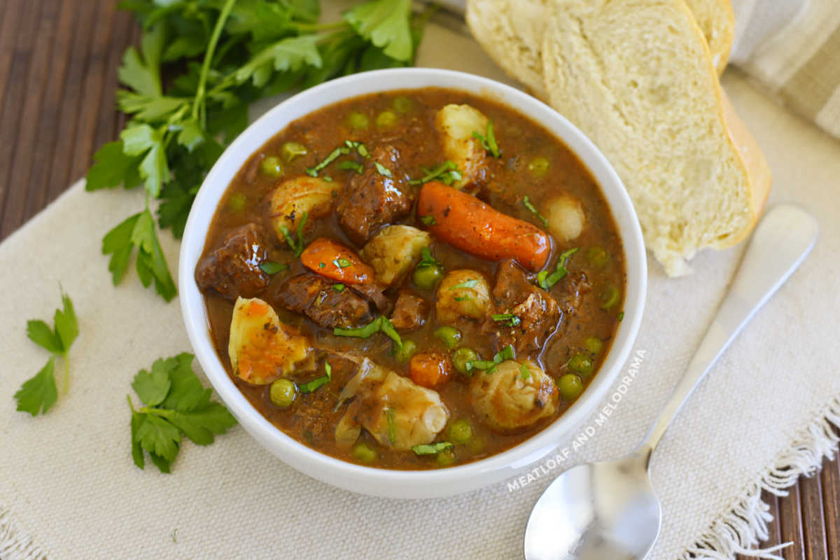 instant pot beef stew with red wine potatoes and carrots and peas in white bowl