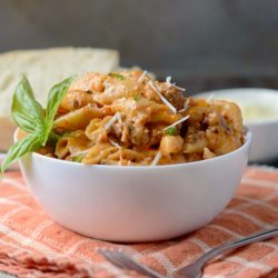 Instant Pot creamy sausage and shells pasta in a white serving bowl
