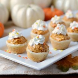 pumpkin cheesecake cookie cups with whipped cream on a serving tray for Thanksgiving