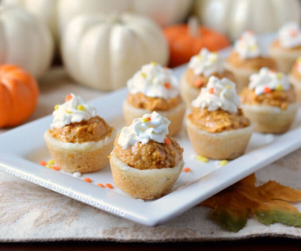 pumpkin cheesecake cookie cups with whipped cream on a serving tray for Thanksgiving