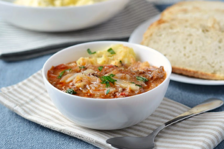 instant pot cabbage roll soup over mashed potatoes in a white bowl with bread