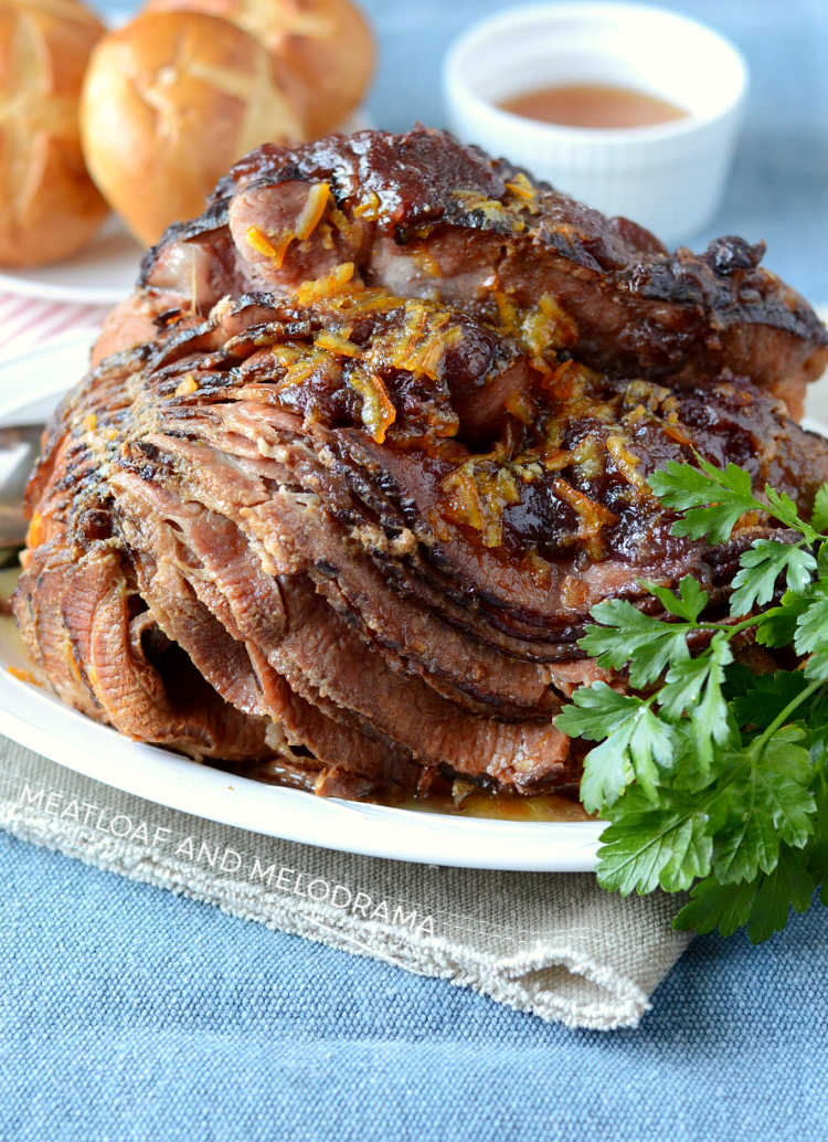 instant pot ham with cranberry orange sauce and parsley on white serving platter