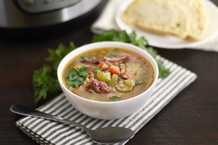 instant pot ham and lentil soup in a white bowl with bread