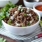 instant pot korean ground beef topped with scallions over rice in white bowl