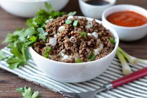 instant pot korean ground beef topped with scallions over rice in white bowl