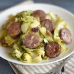 pan fried kielbasa and cabbage on a white plate