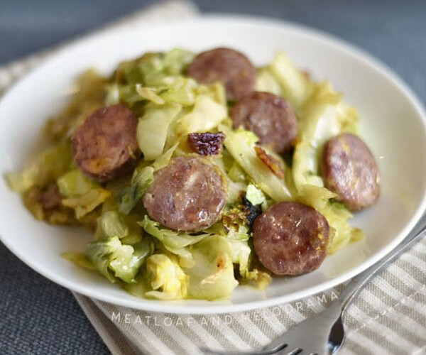 pan fried kielbasa and cabbage on a white plate