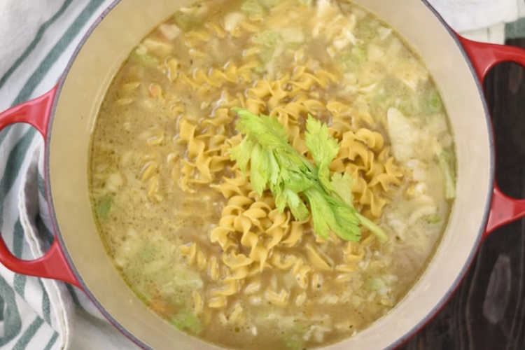 add homemade chicken stock and egg noodles to dutch oven for soup