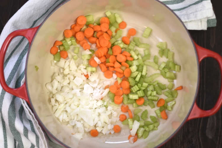 diced onions carrots and celery in dutch oven for homemade chicken soup