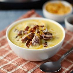 instant pot potato soup with kielbasa cheddar cheese and bacon in white bowl